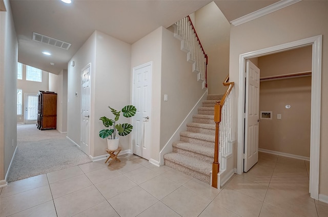 stairs featuring ornamental molding and tile patterned floors