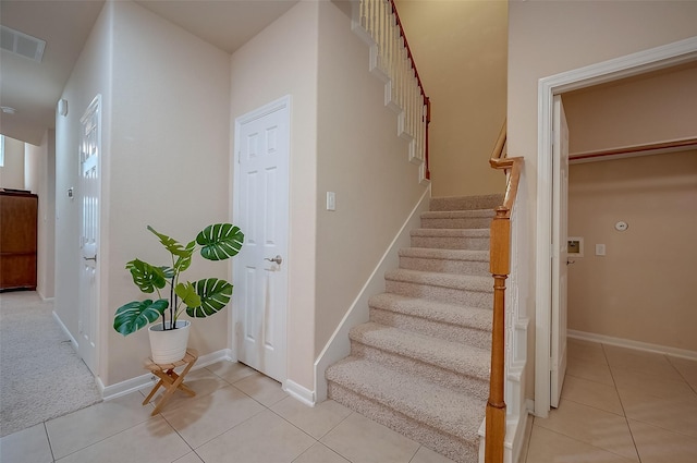 staircase featuring tile patterned flooring