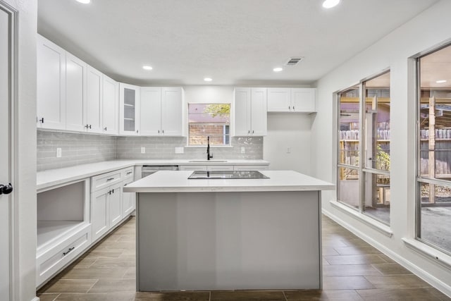 kitchen with white cabinets, sink, and a center island