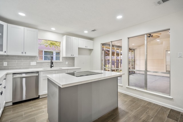 kitchen with white cabinets, a center island, dishwasher, sink, and black electric cooktop