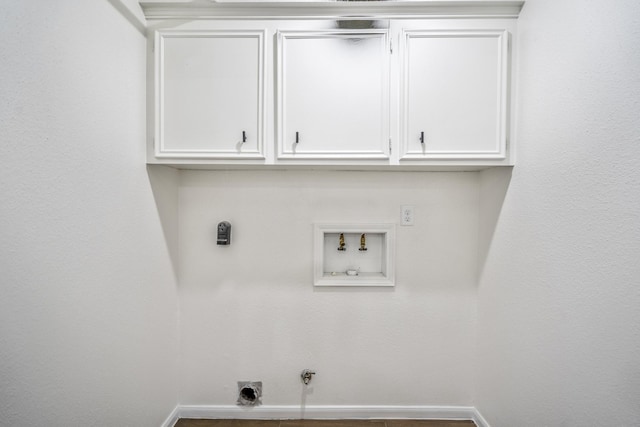 laundry area with hookup for a gas dryer, hookup for an electric dryer, hookup for a washing machine, and cabinets