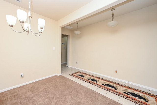 tiled spare room with an inviting chandelier