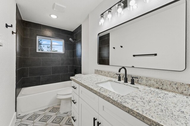 full bathroom featuring toilet, tiled shower / bath, and vanity