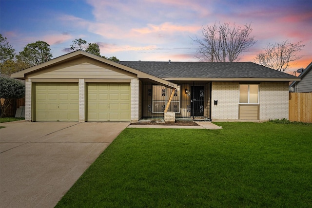 ranch-style house with a garage and a lawn