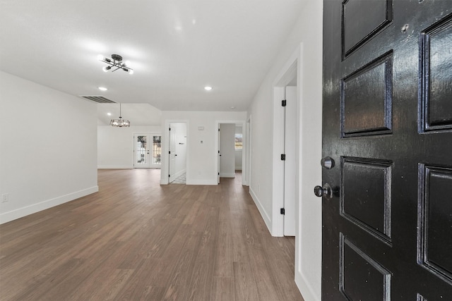 foyer with hardwood / wood-style flooring and an inviting chandelier