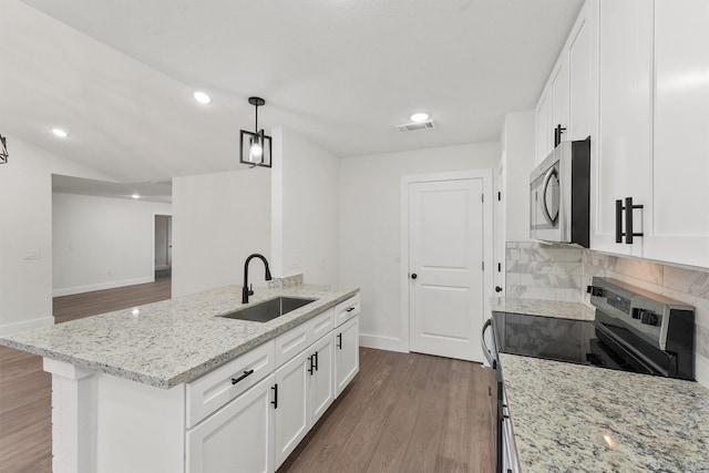 kitchen with decorative backsplash, sink, a kitchen island with sink, stainless steel appliances, and white cabinets