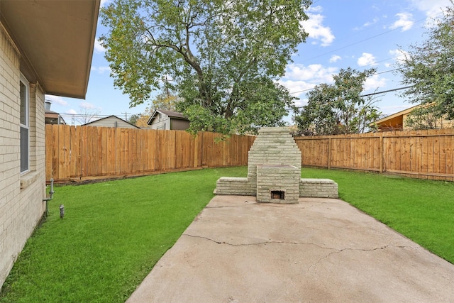 view of yard with a patio area and an outdoor stone fireplace