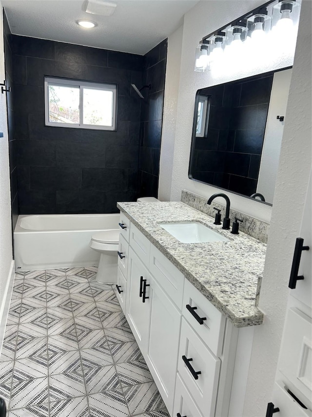 full bathroom featuring toilet, vanity, and tiled shower / bath combo