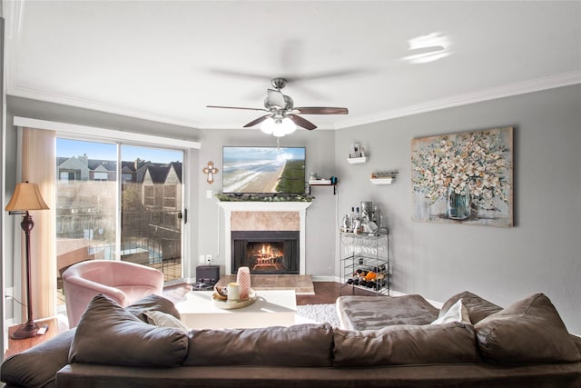 living room with hardwood / wood-style flooring, crown molding, and ceiling fan