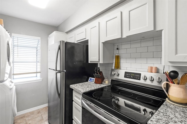 kitchen with white cabinetry, appliances with stainless steel finishes, stacked washer / drying machine, and backsplash