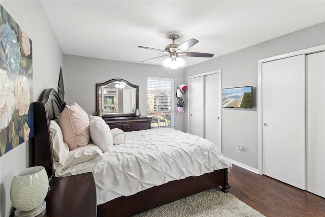 bedroom featuring ceiling fan, dark hardwood / wood-style flooring, and multiple closets