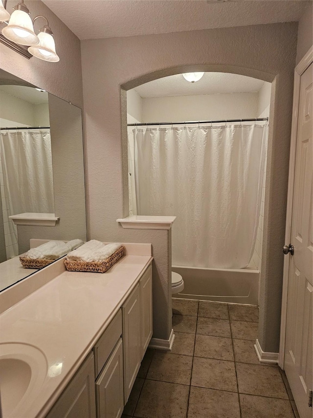 full bathroom featuring shower / tub combo, vanity, a textured ceiling, tile patterned floors, and toilet