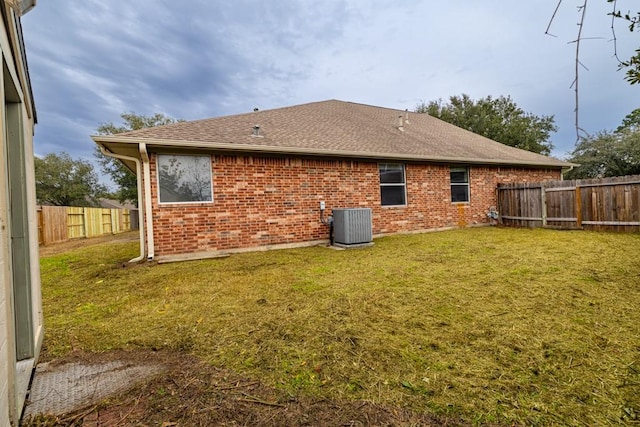 back of house featuring cooling unit and a yard