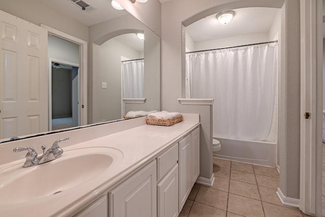 full bathroom featuring tile patterned flooring, vanity, toilet, and shower / bath combo with shower curtain