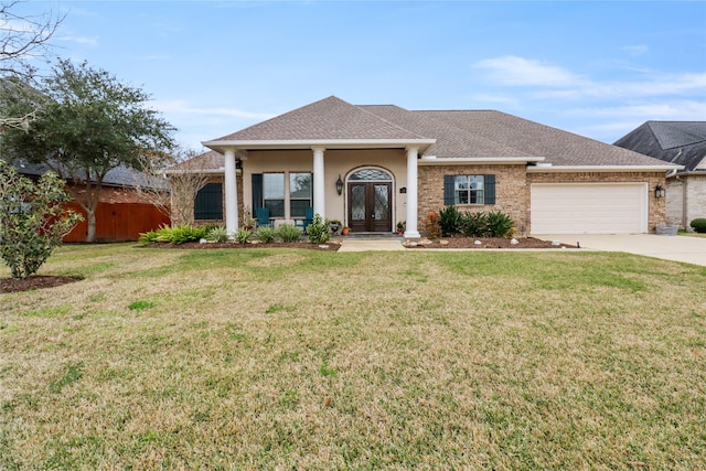 view of front facade with a front yard, a garage, a porch, and french doors