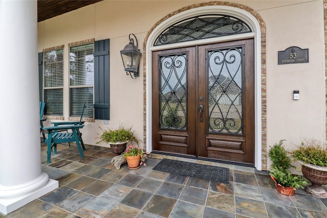 entrance to property featuring a porch and french doors