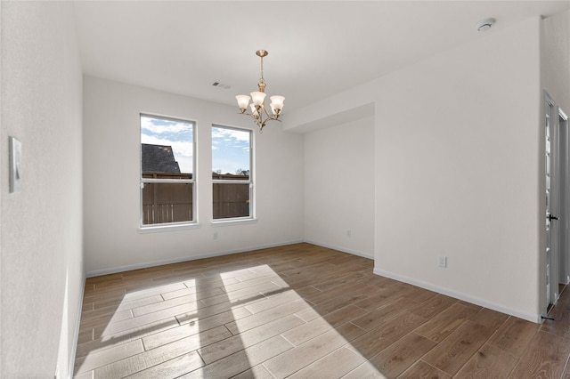 unfurnished room with a chandelier