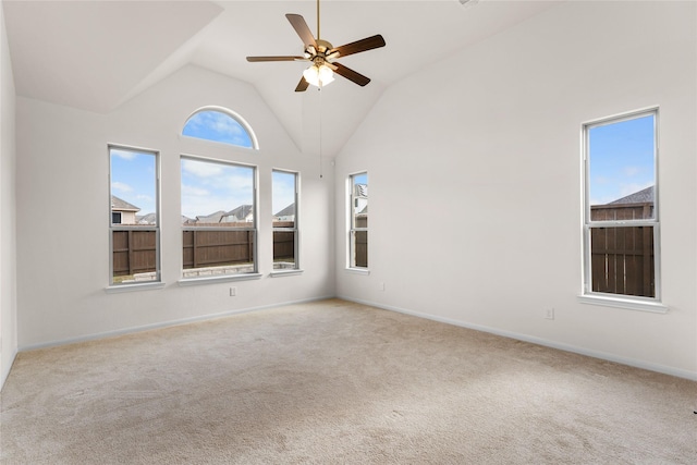 carpeted empty room with ceiling fan and high vaulted ceiling