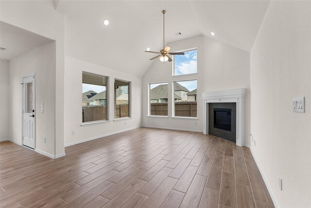 unfurnished living room featuring ceiling fan, a fireplace, and high vaulted ceiling