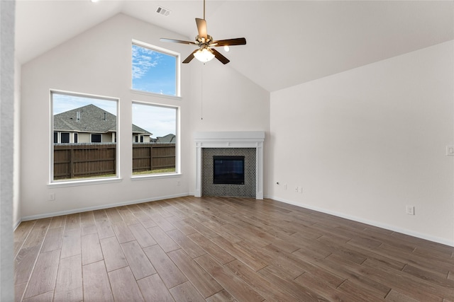 unfurnished living room with ceiling fan, wood-type flooring, and high vaulted ceiling