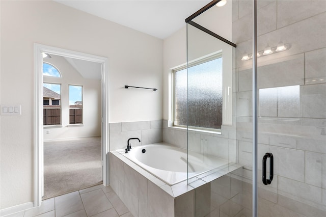 bathroom featuring vaulted ceiling, tile patterned floors, and shower with separate bathtub