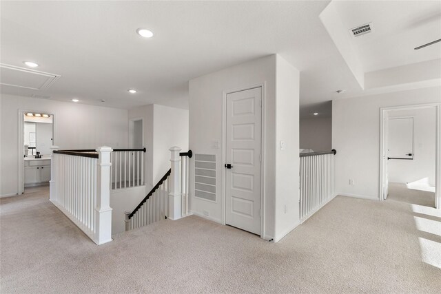 hall featuring light colored carpet