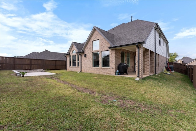 back of house featuring a patio area and a yard