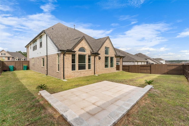 rear view of property with a lawn and a patio