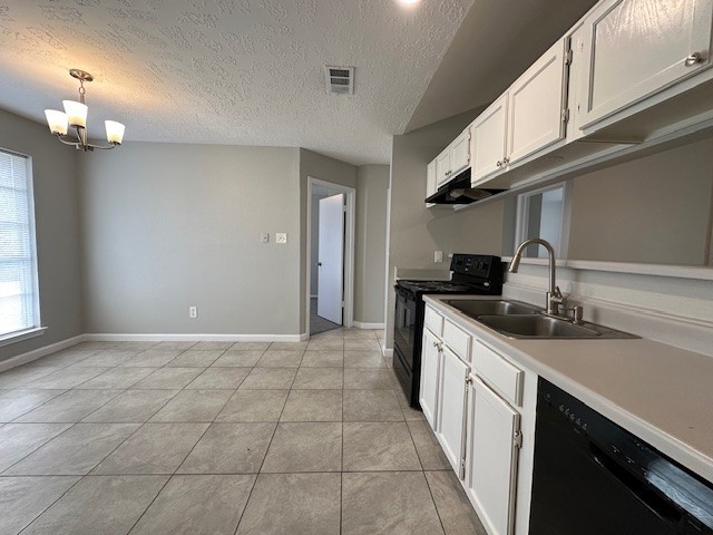 kitchen featuring a textured ceiling, black appliances, decorative light fixtures, white cabinetry, and sink