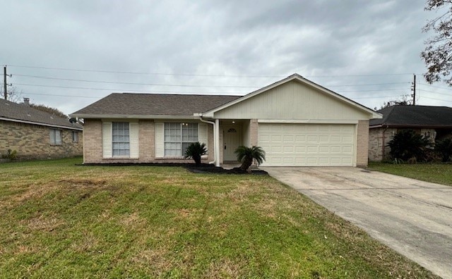 single story home featuring a garage and a front yard