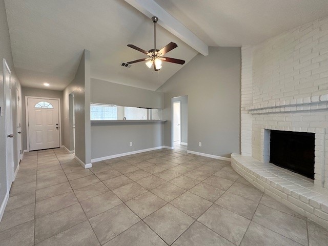 unfurnished living room with ceiling fan, lofted ceiling with beams, a brick fireplace, and light tile patterned flooring