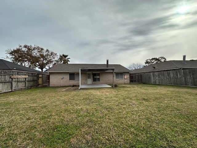 rear view of house featuring a patio area and a yard