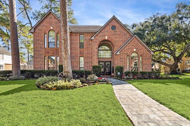 tudor home with a front yard and french doors