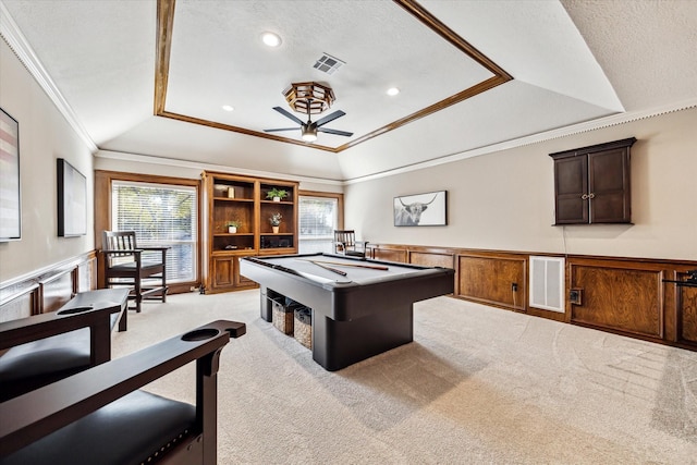 game room featuring ornamental molding, light colored carpet, and a raised ceiling