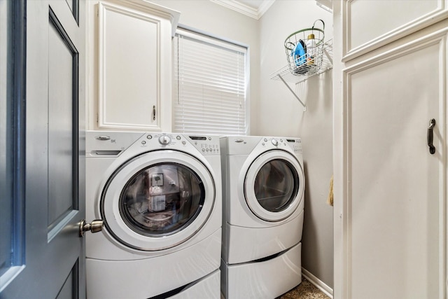 laundry area with cabinets, ornamental molding, and washing machine and clothes dryer