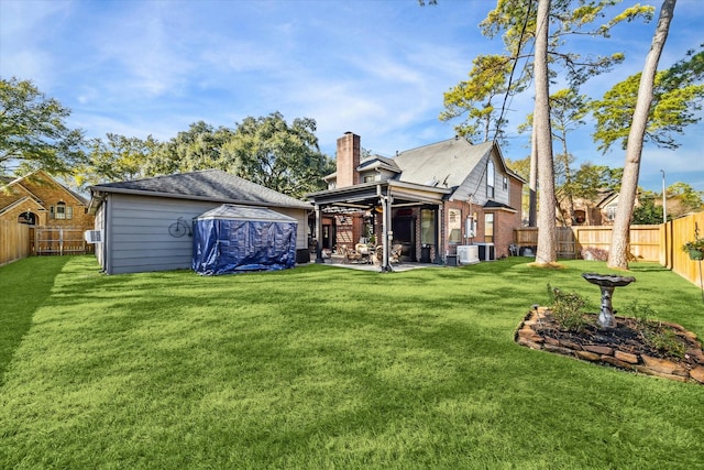 rear view of house featuring a lawn, central AC, and a patio