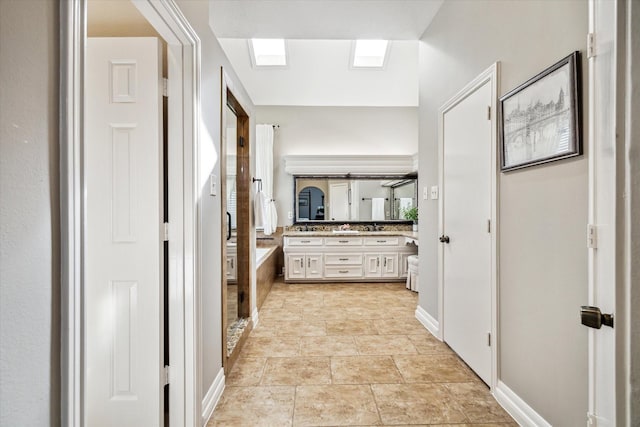 hallway featuring sink and a skylight