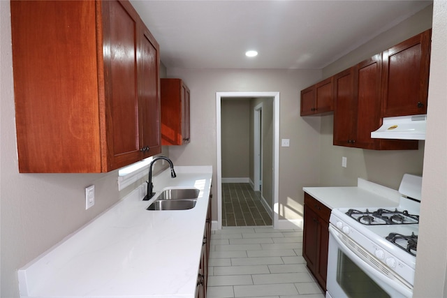 kitchen with light tile patterned floors, sink, and white gas stove