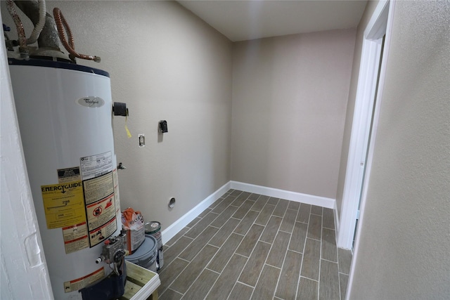 laundry room featuring water heater and dark hardwood / wood-style flooring