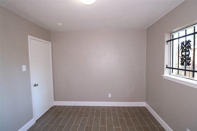 unfurnished room featuring dark wood-type flooring and plenty of natural light