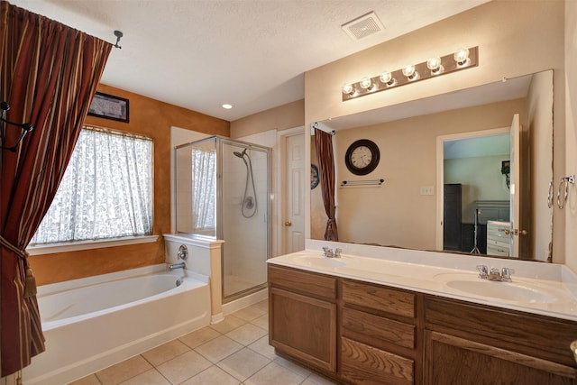 bathroom featuring vanity, plus walk in shower, tile patterned flooring, and a textured ceiling