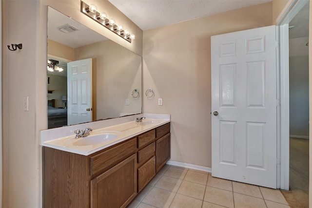 bathroom with tile patterned flooring, vanity, and a textured ceiling