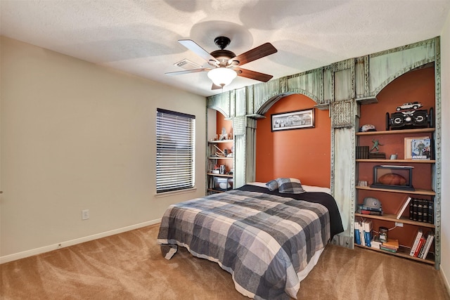 carpeted bedroom with ceiling fan and a textured ceiling