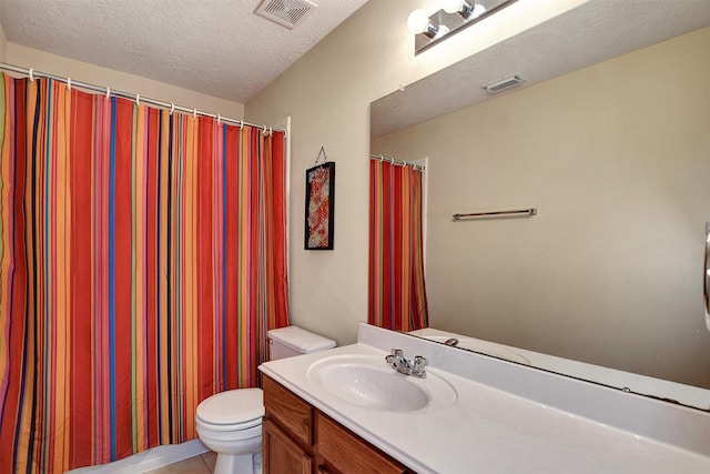 bathroom featuring vanity, tile patterned floors, a textured ceiling, and toilet