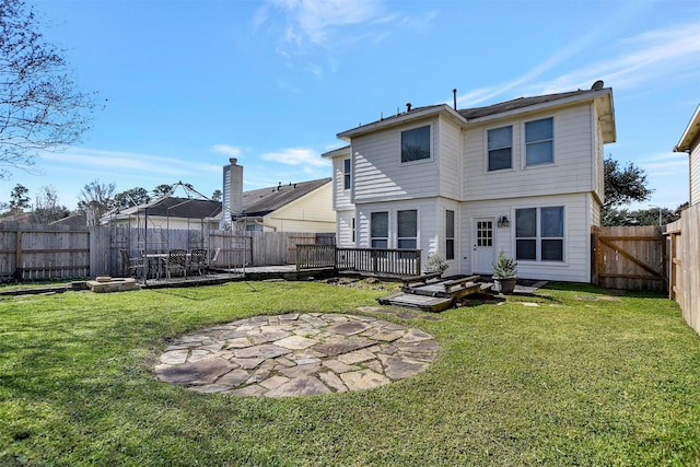 rear view of property featuring a patio area, a deck, and a lawn