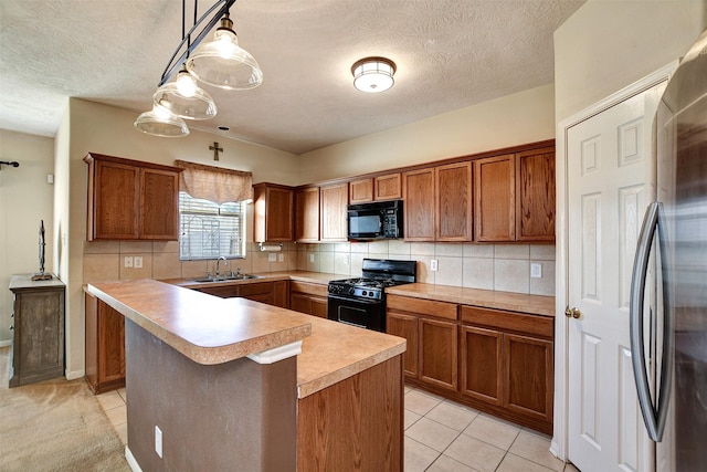 kitchen with sink, hanging light fixtures, light tile patterned floors, decorative backsplash, and black appliances