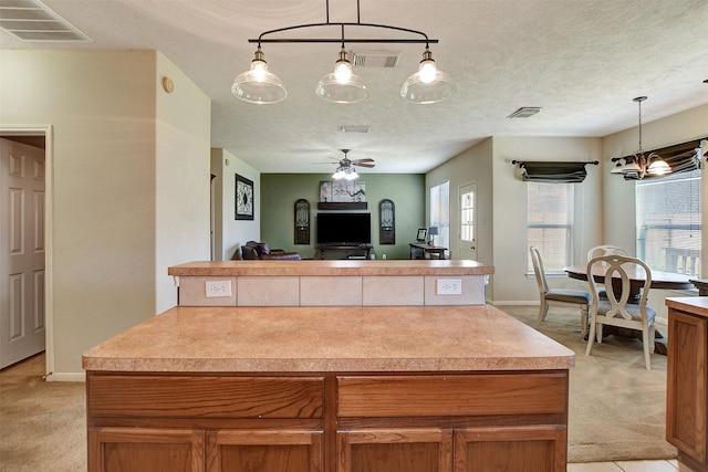 kitchen with light colored carpet, a textured ceiling, and a kitchen island