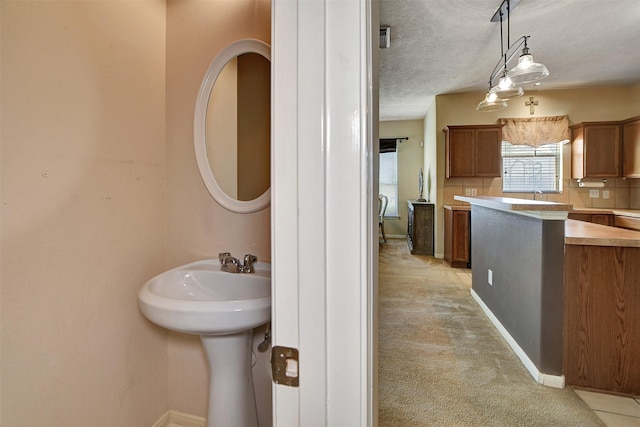 bathroom featuring decorative backsplash and a textured ceiling