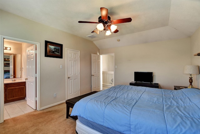 bedroom with sink, ceiling fan, connected bathroom, vaulted ceiling, and light colored carpet