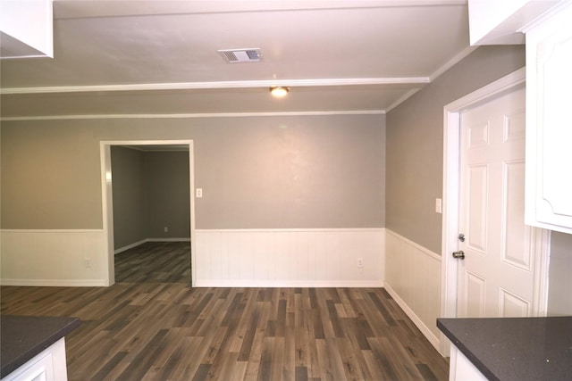 spare room with dark wood-type flooring and crown molding